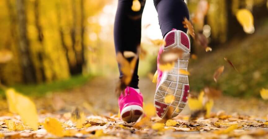 Nahaufnahme von Läuferfüßen, die im Herbst laufen, lässt Trainingsübung