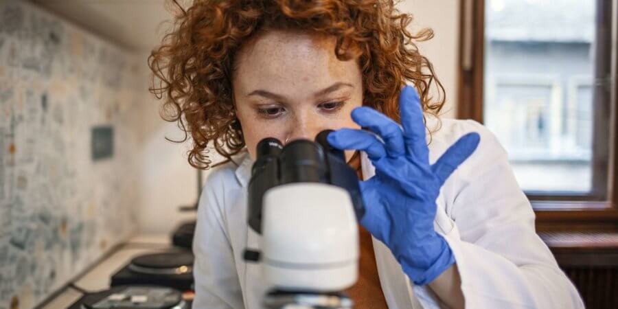 Junger Wissenschaftler, der mit dem Mikroskop arbeitet