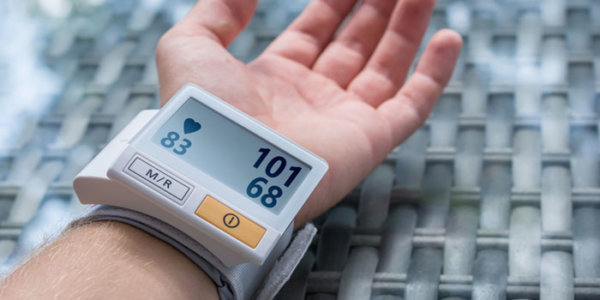 Blutdruckgerät misst den Blutdruck am Handgelenk eines Mannes
