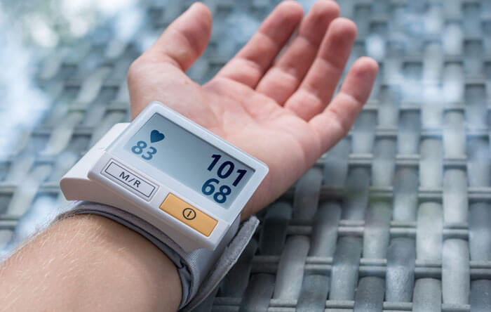 Blutdruckgerät misst den Blutdruck am Handgelenk eines Mannes