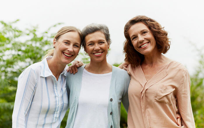 Portrait of happy mature women standing together in park