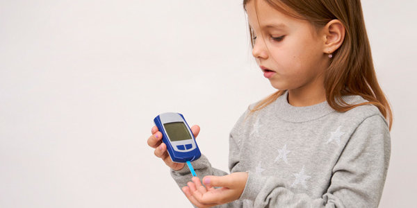 Diabetes in children's concept. Little girl checking blood sugar level