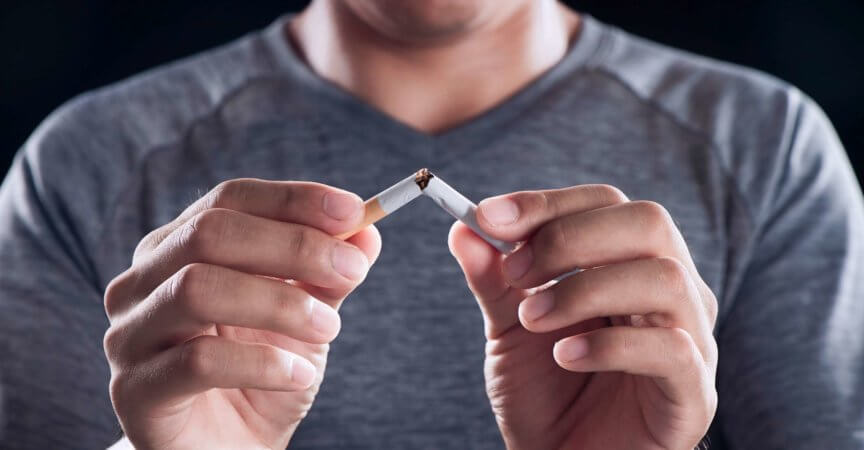 Beenden Sie das Rauchen, Männerhände brechen die Zigarette für eine gute Gesundheit.