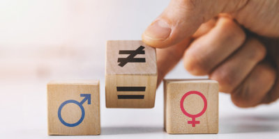 gender equality and discrimination concept - hand putting wooden blocks with symbols