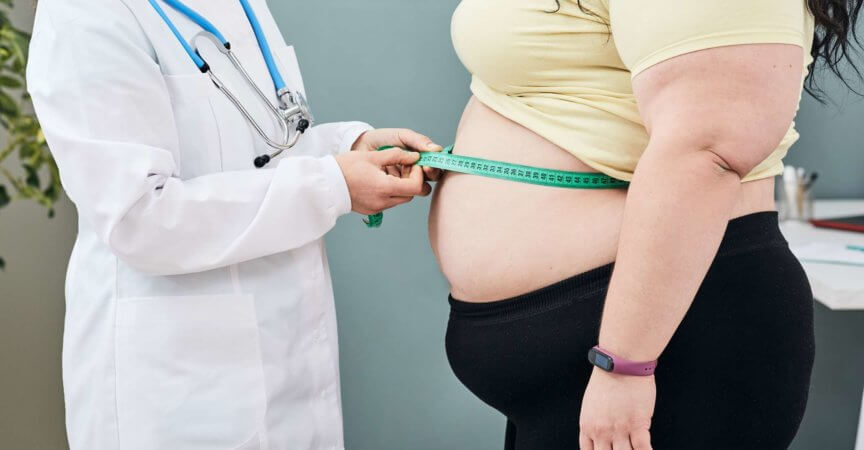 Fettleibigkeit, ungesundes Gewicht. Ernährungsberater untersucht die Taille einer Frau mit einem Messband, um eine Diät zur Gewichtsabnahme zu verschreiben