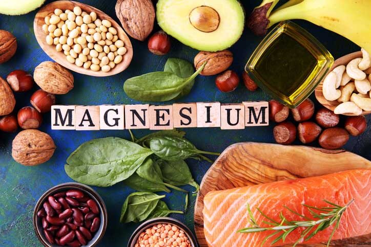 Magnesiumhaltige Produkte: Bananen, Mandeln, Avocado, Nüsse und Spinat und Eier auf dem Tisch