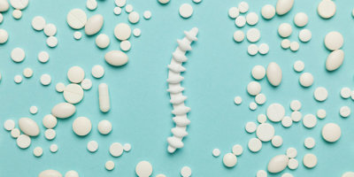 Tabletten, die ein Rückgrat bilden auf türkis-blauem Hintergrund