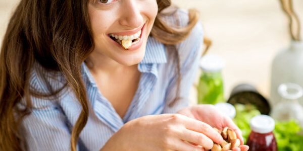 Junge Frau isst Nüsse